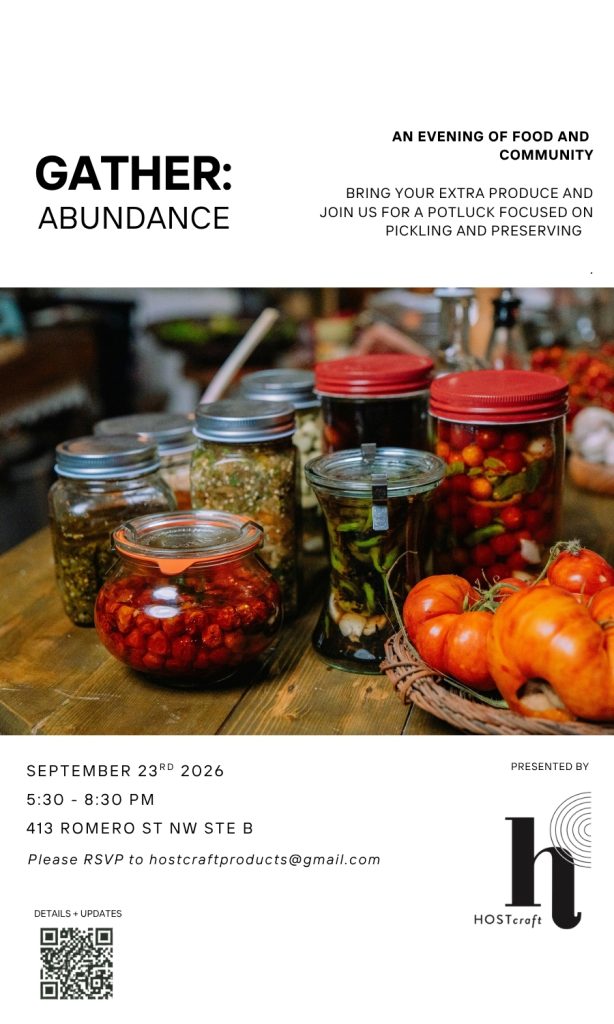 Jars of pickled vegetables and fresh tomatoes on a wooden table for a community potluck event focused on preserving and pickling.
